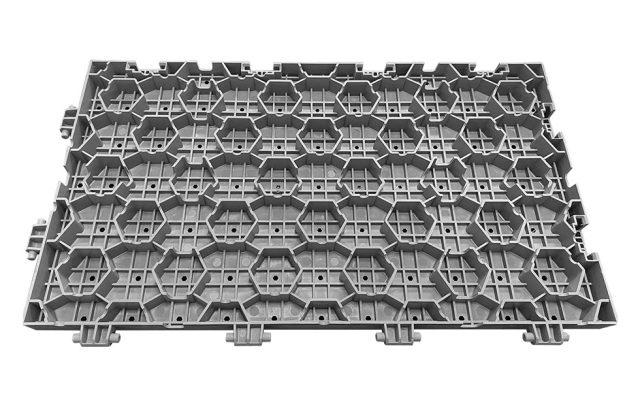 Installed 60×33×3cm load-bearing PP interlocking lawn protection event flooring tiles covering an outdoor sports center or festival venue grass surface, showing full modular coverage, flush concealed joint surface, and the temporary event flooring configuration rated at greater than 15 tons per square meter bearing capacity, conforming to GB/T 24508-2020 standard.
