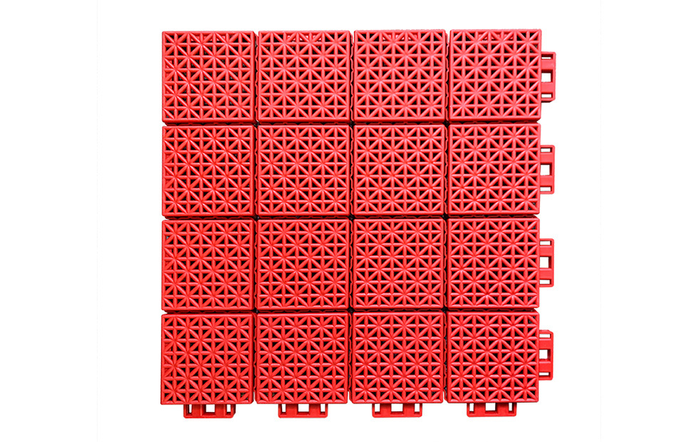 Installed 300×300×13mm soft connection PP interlocking sports tiles on an indoor basketball court or multi-sport venue floor, showing full-coverage large-area modular installation with consistent different-sized block surface pattern, uniform joint alignment, and no surface buckling or warping across the court area.
