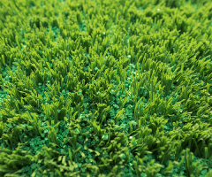 Close-up macro view of five-leaf type TPE eco-friendly artificial grass infill granules showing the five-lobe radial particle geometry designed to interlock within synthetic turf fiber piles for lateral migration resistance on football, rugby, and multi-sport synthetic grass surfaces.