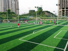 Applied TPE eco-friendly artificial grass infill granules distributed within the fiber pile of a synthetic turf football field surface, showing the infill depth and fiber interaction of the TPE granule in a real-world sports turf installation context.