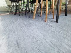 Copolymer rubber floor tile installed as gym flooring in a commercial fitness facility, showing full tile field layout, anti-skid surface texture, tile seam alignment, and installed appearance under gym equipment loading