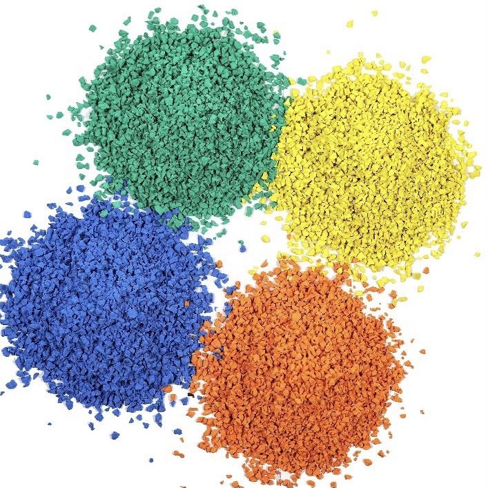 Multi-pigment TPV playground granule heap showing sorted fractions in red, black, white, and yellow, with 0.5–2mm through 1–4mm particle size distributions, specific gravity 1.55 g/cm³, for wet-pour playground and sport court surfacing procurement.