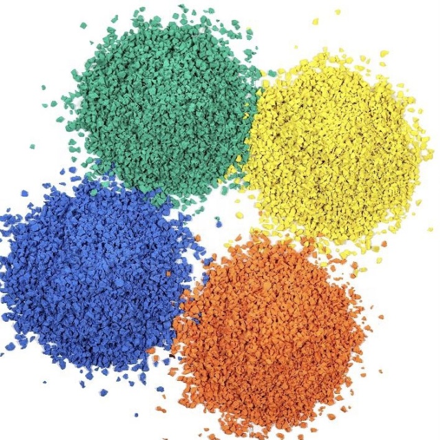 Multi-pigment TPV playground granule heap showing sorted fractions in red, black, white, and yellow, with 0.5–2mm through 1–4mm particle size distributions, specific gravity 1.55 g/cm³, for wet-pour playground and sport court surfacing procurement.