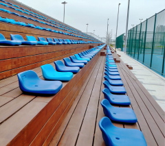 Outdoor stadium seating installation featuring HDPE 5502 blow molded seats deployed across a multi-row bleacher array, showing full structural context and seating capacity layout