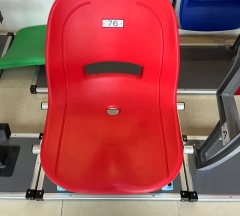 Outdoor arena seating installation featuring Eco-H HDPE 5502 blow molded full-backrest stadium seats across a tiered spectator section, showing color distribution, row spacing, and structural installation context