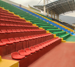 HDPE blow molded stadium seats in wall installation configuration mounted to vertical riser faces on a bleacher structure, showing bracket interface and seat positioning