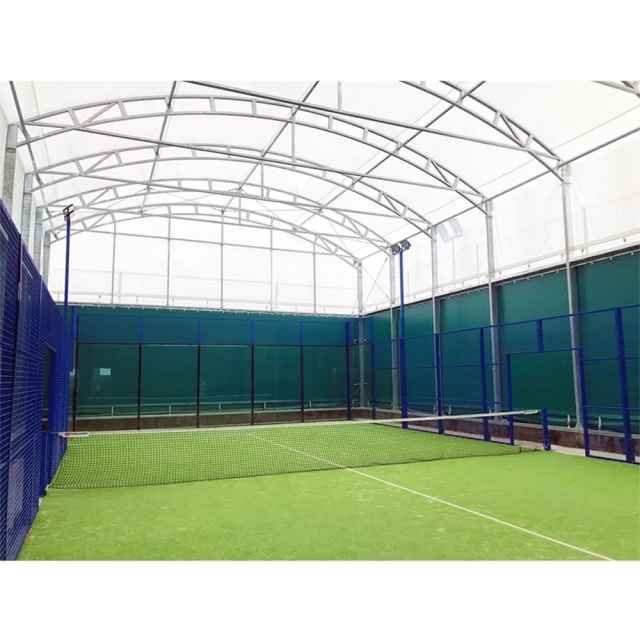 Padel court H007R simple roof steel structure assembly showing hot dip galvanized roof rafter and purlin framing, roof-to-court perimeter frame integration at foundation anchor points, and structural steel canopy geometry above 20×10m court footprint during installation phase