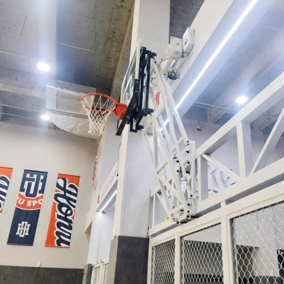 Close-up of wall mounted basketball stand wall bracket faceplate secured with 4 carriage bolts, showing bolted adjustable arm system anchor points, heavy-duty two welded-link chain stabilizers in active play position, and steel tubing frame mounting interface