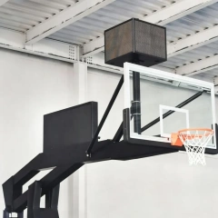 High-magnification detail of FIBA Level 1 portable basketball hoop showing 1800×1050mm 12mm clear view tempered glass backboard panel edge and full cover safety padding across base and front structure, illustrating glazing thickness and impact protection coverage