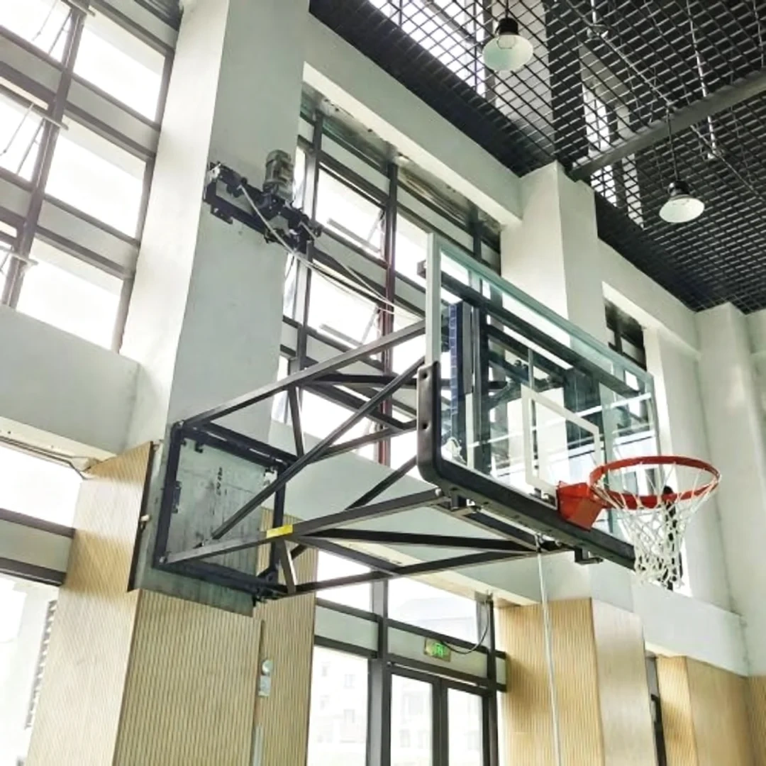 High-magnification detail of wall mounted basketball stand electric winch mechanism showing motor drum and cable feed assembly, remote control receiver unit, and connection to 180×105cm 12mm tempered glass backboard frame for motorized fold-up deployment
