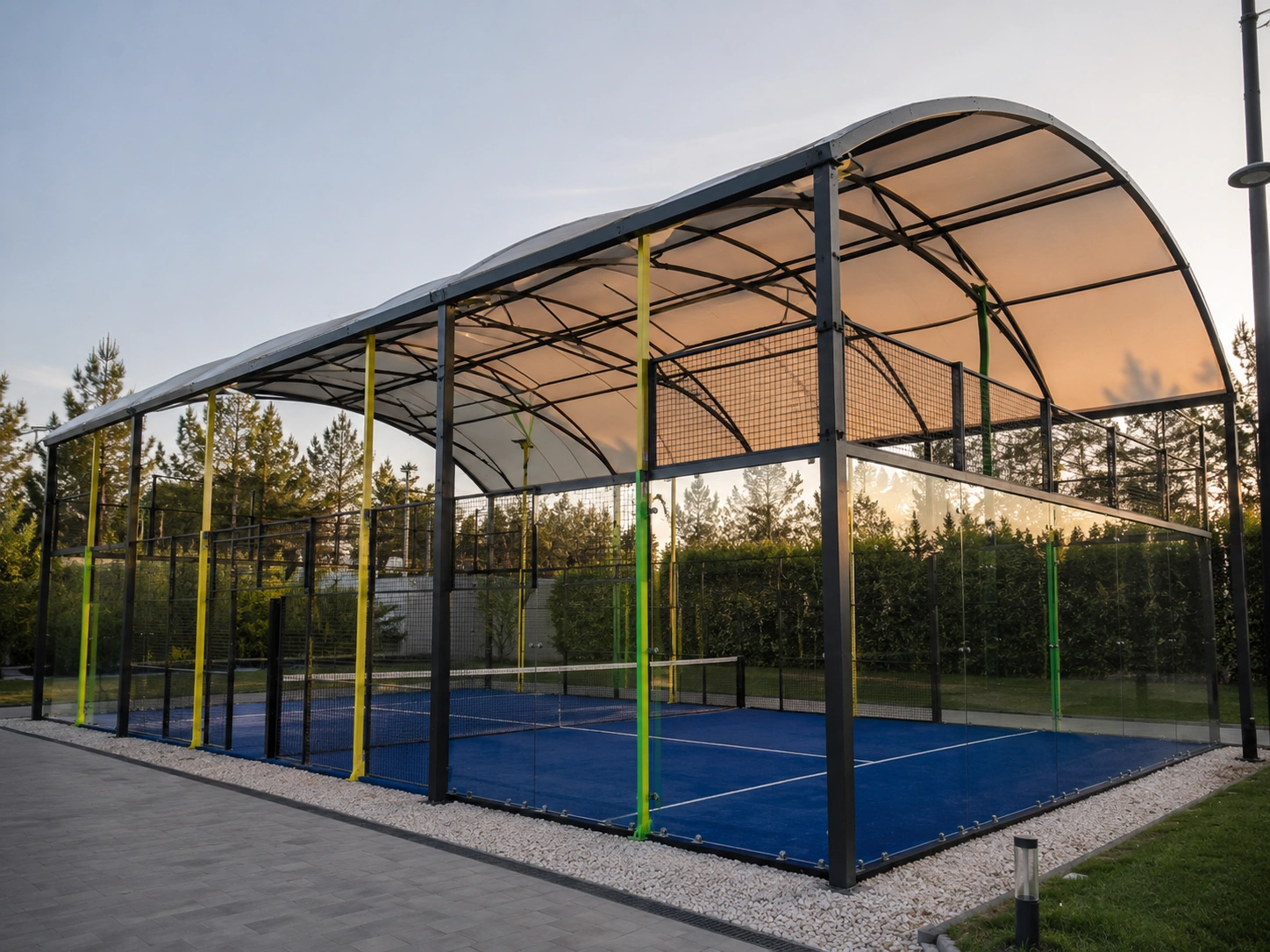 Panoramic padel court with PVC roof and tempered glass walls, full exterior view