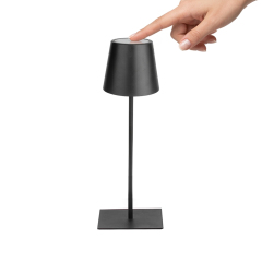 User demonstrating top-touch stepless dimming on a black cordless lamp to adjust brightness and color temperature.