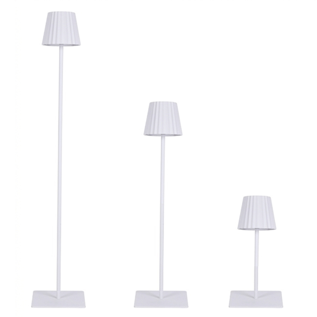 Minimalist white rechargeable lamp with pleated design and modular height segments for hotel lighting projects.