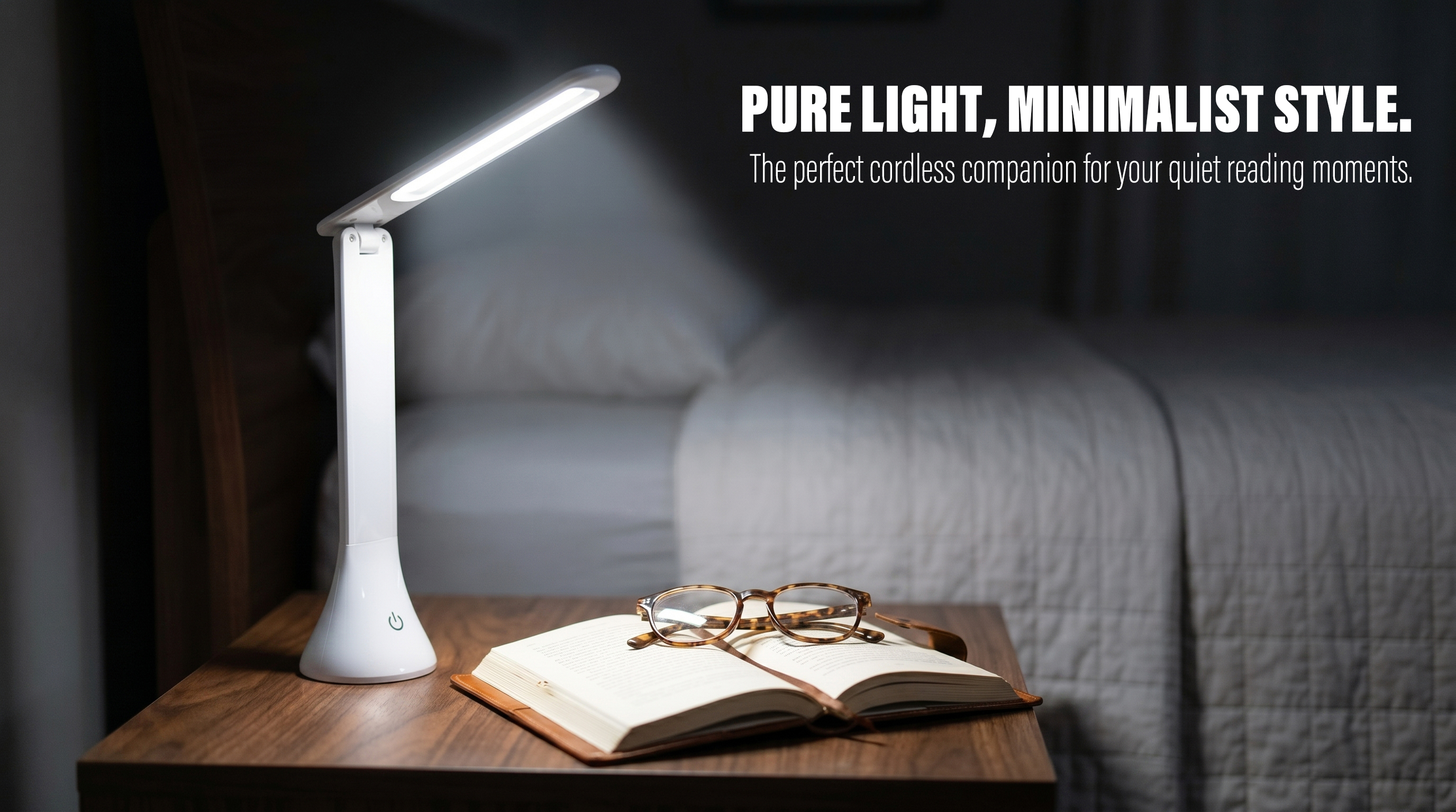 Minimalist white foldable LED desk lamp illuminating a book on a wooden nightstand in a bedroom setting