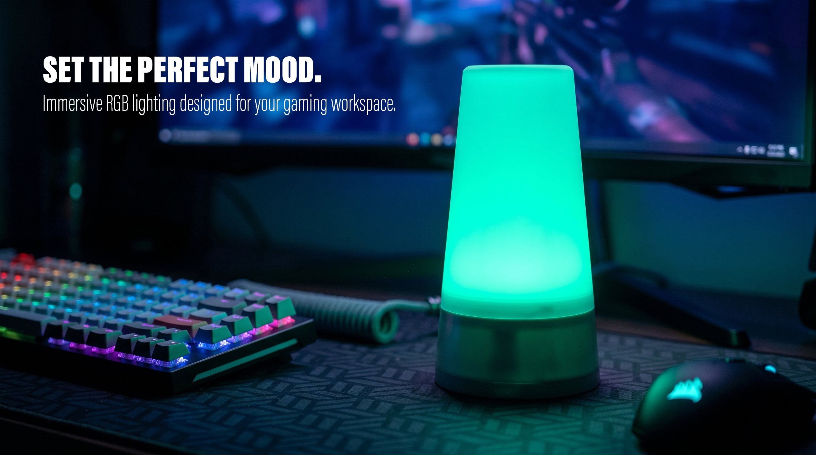 A cylindrical RGB ambient light glowing green on a modern gaming desk setup with a keyboard and mouse