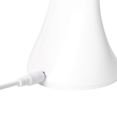 Close up of the USB charging cable connected to the white folding desk lamp