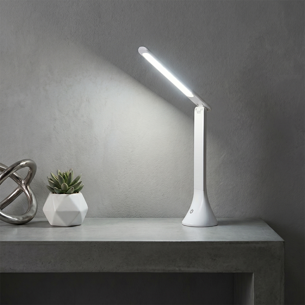 Portable COB folding LED desk lamp illuminating a modern workspace