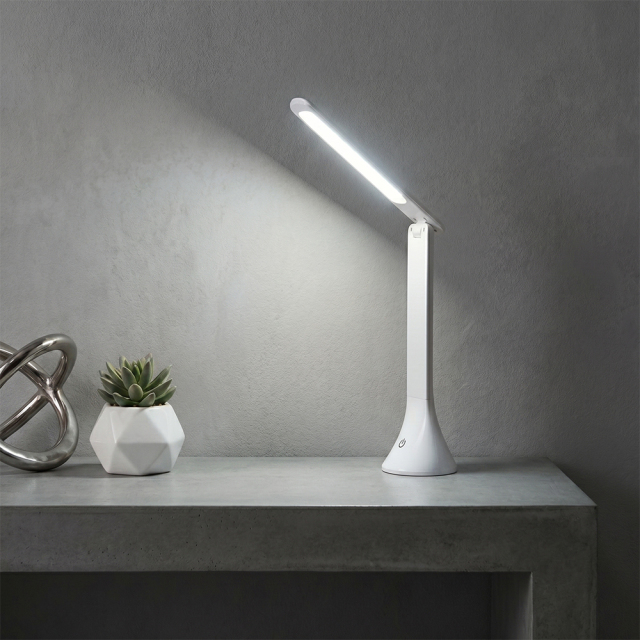 Portable COB folding LED desk lamp illuminating a modern workspace