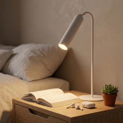 Multifunctional 4-in-1 white LED table lamp used as a bedside reading light in a modern minimalist bedroom.
