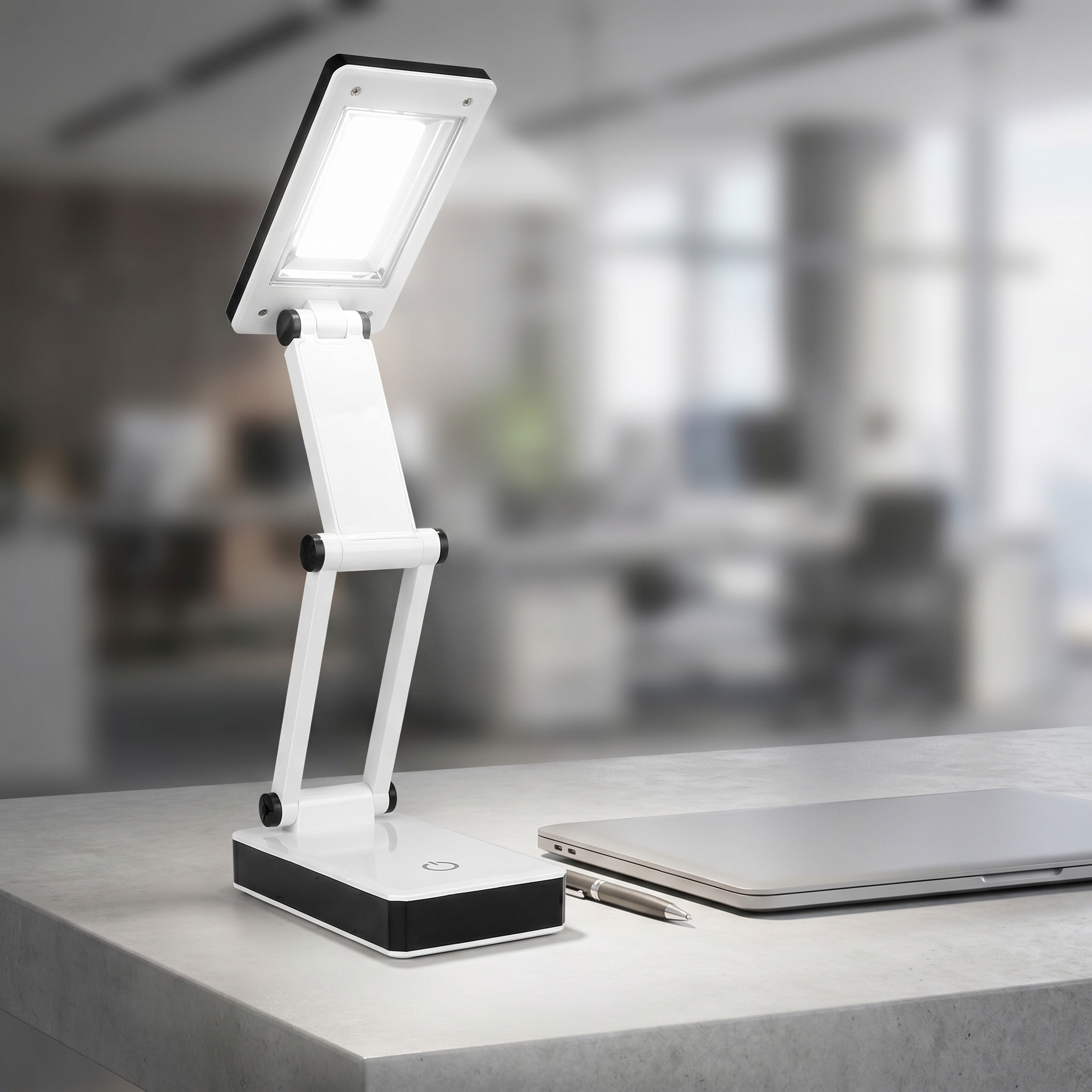 An adjustable white and black folding COB LED desk lamp illuminated on an office desk next to a laptop and pen