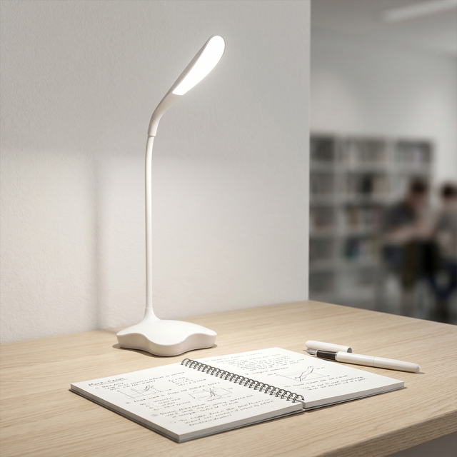 A white flexible gooseneck LED reading desk lamp illuminating an open notebook on a wooden study table in a classroom background
