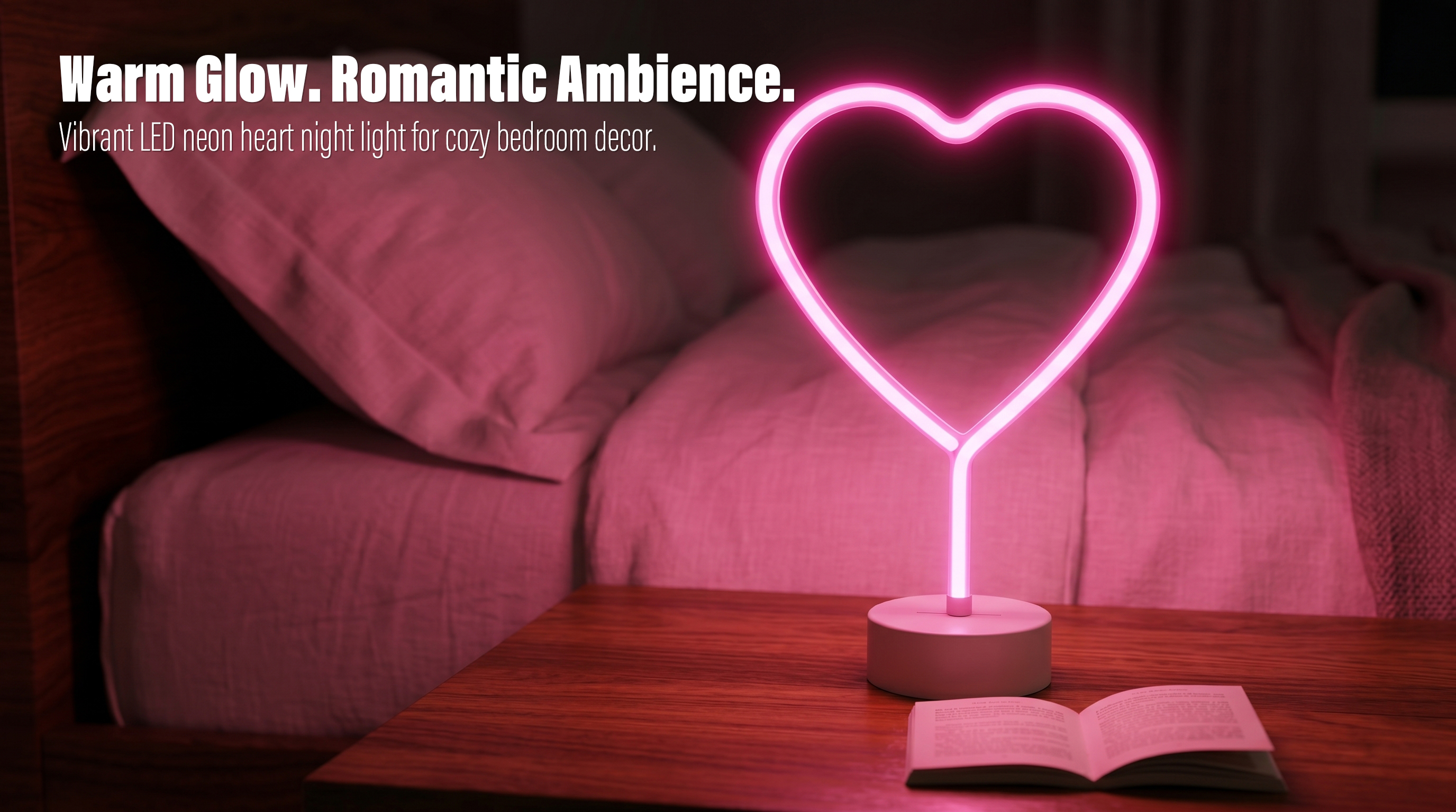 A pink LED heart neon sign table lamp glowing on a wooden bedside table next to an open book in a dimly lit bedroom