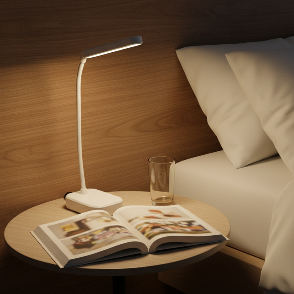 An illuminated white cordless bedside lamp casting a warm soft glow next to a glass of water on a wooden nightstand