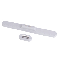 Studio photograph showing the white reading light bar detached from its small separate magnetic wall mount base