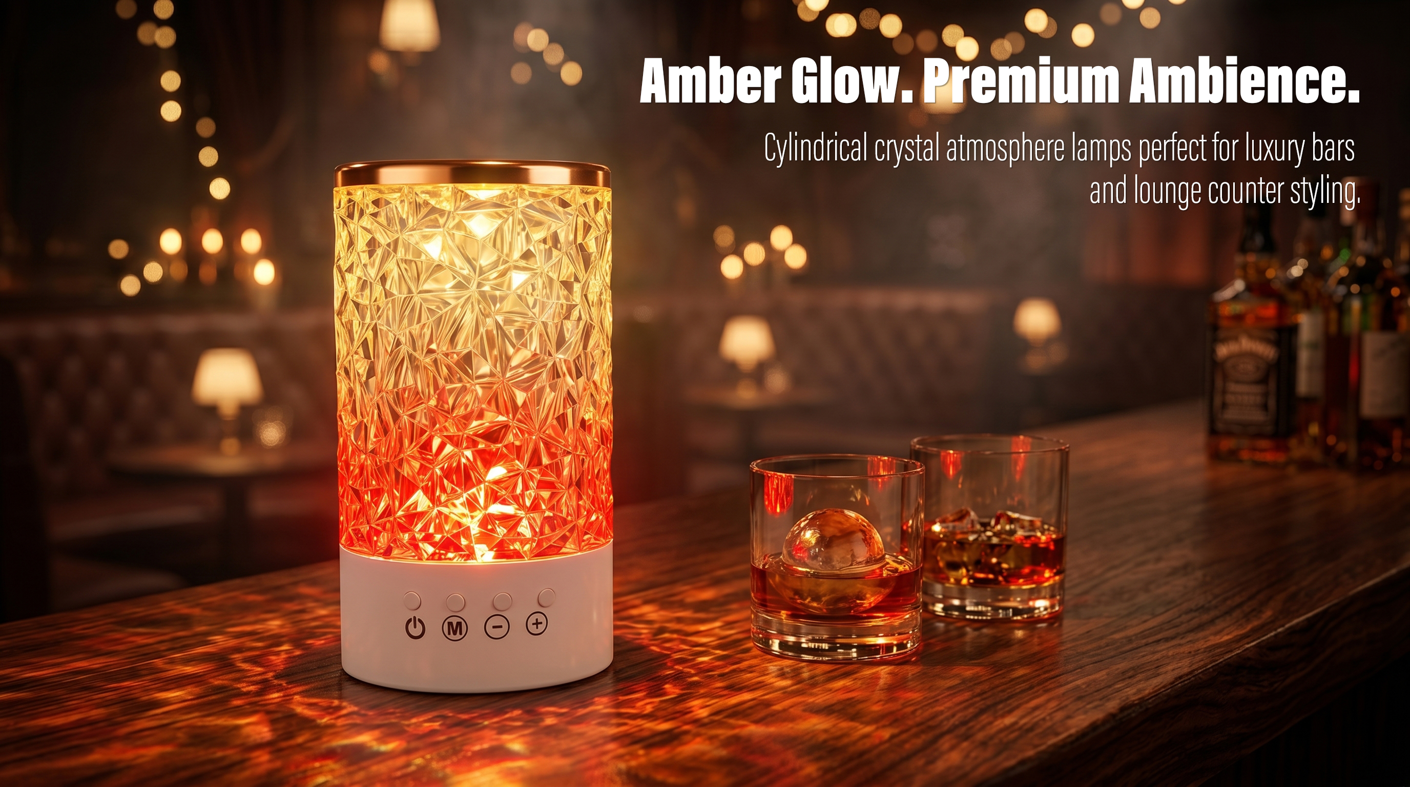 An illuminated cylindrical crystal atmosphere lamp with multi-function buttons casting warm amber reflections on a wooden bar counter next to whiskey glasses.