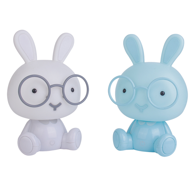 Studio view of two cartoon rabbit LED night lights in white and light blue variants with round glasses on a white background