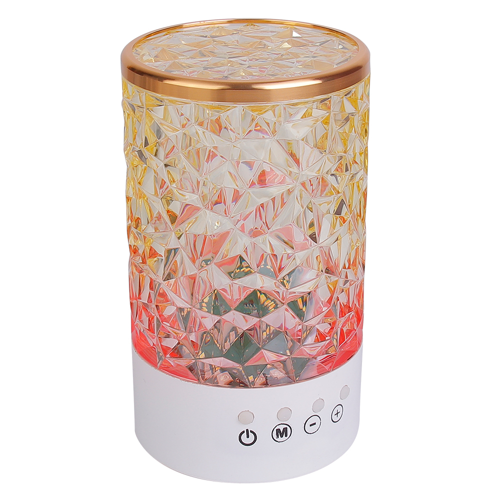 Three-quarter studio photograph of an elegant cylindrical crystal desk light with a gold rim and diamond-cut pattern