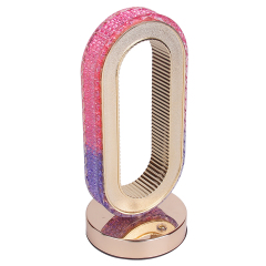 Slightly low-angle studio photograph of a modern decorative oval crystal night light showcasing its reflective metallic base