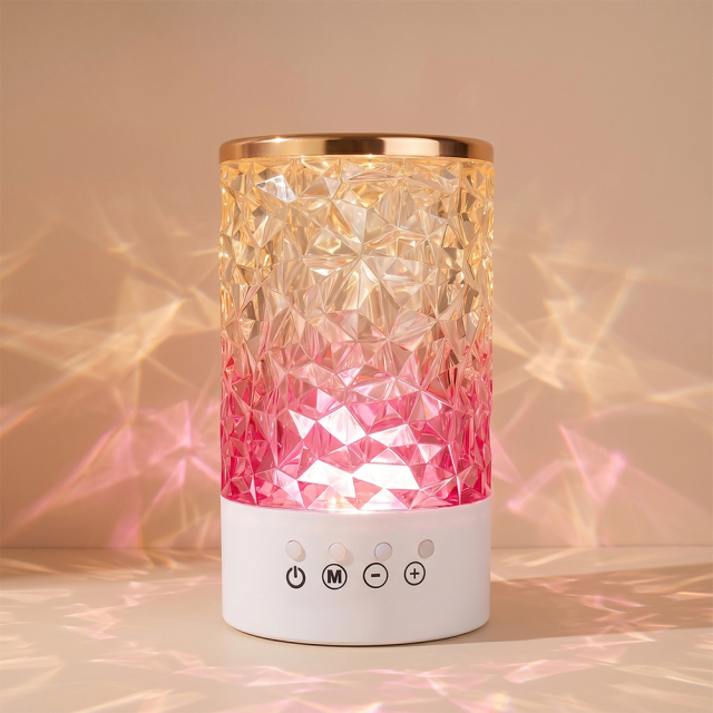 An illuminated crystal atmosphere lamp casting warm pink and orange geometric light patterns onto a wall background