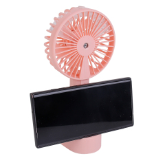 Three-quarter angled studio view of the pink desktop fan with a smartphone placed horizontally into the built-in cradle slot of the base.