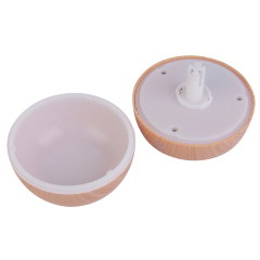 Disassembled studio view of a light wood grain sphere humidifier showing the empty white inner water tank and the upper lid with an atomizing core.
