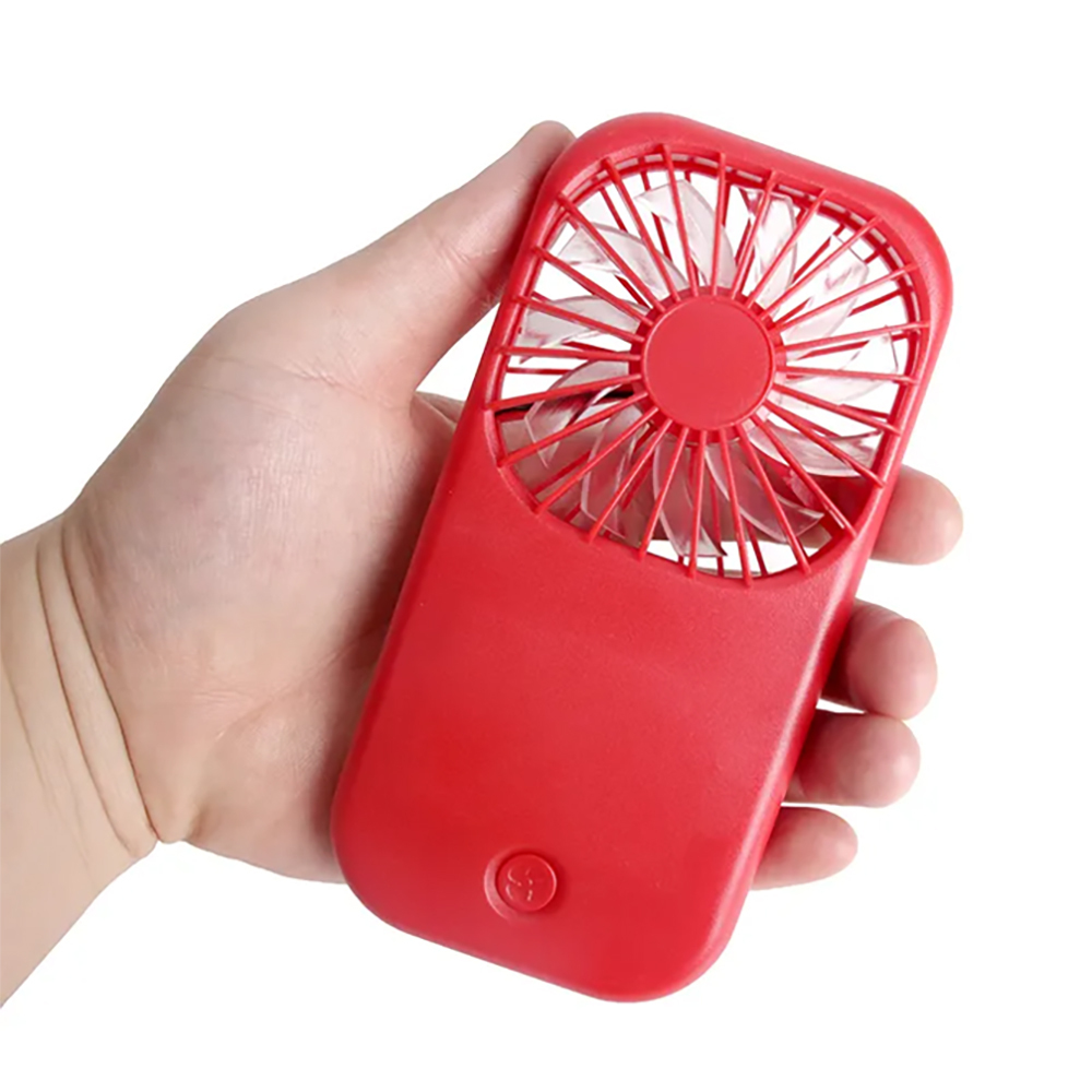 A hand holding the ultra-compact red pocket fan against a white background to demonstrate its portable size.