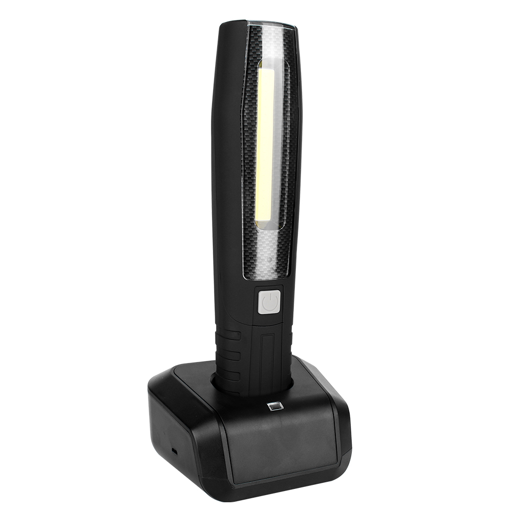 Three-quarter view of a handheld LED inspection light placed on a black charging dock station.