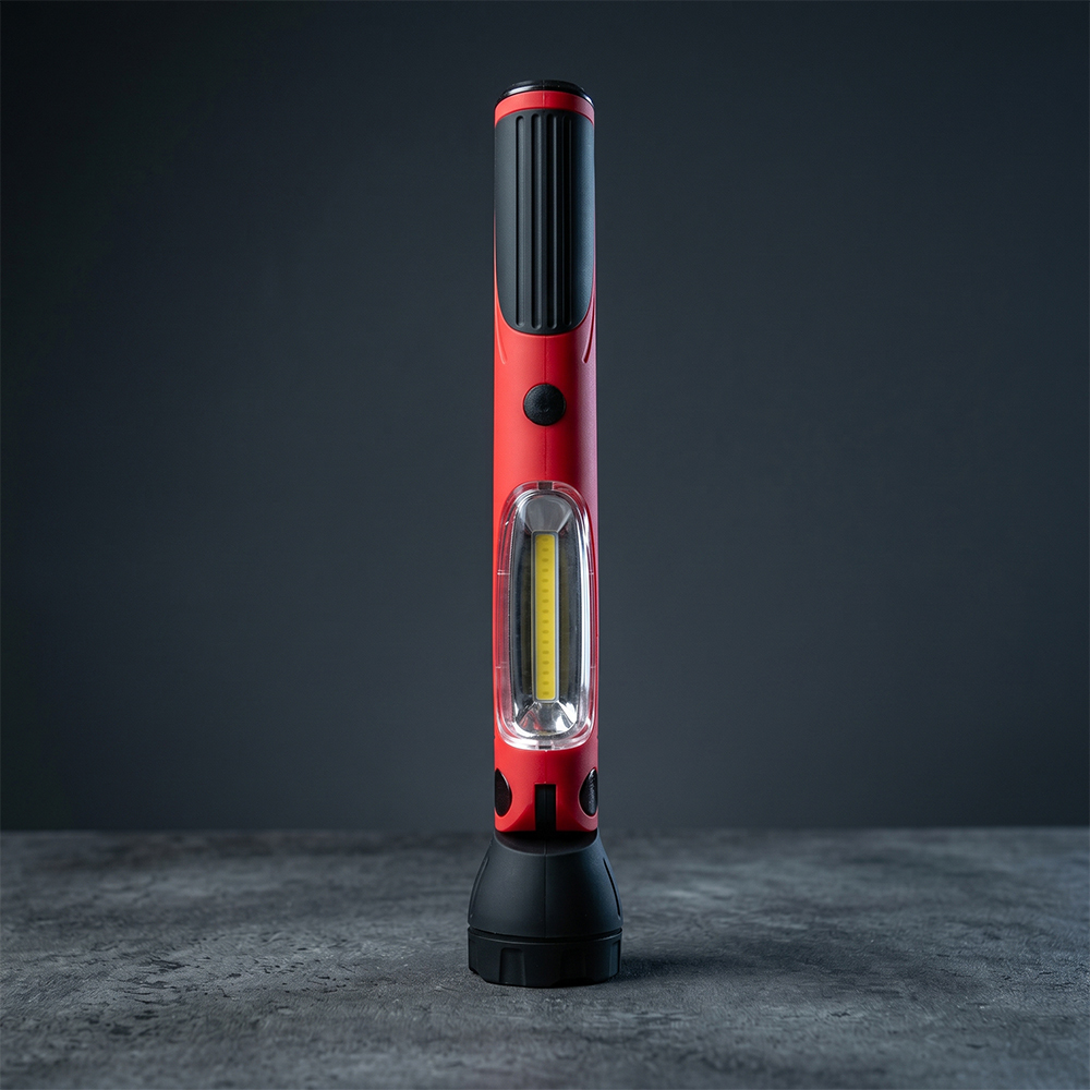 Portable rechargeable LED work light standing on a dark stone surface with a side COB lighting panel.