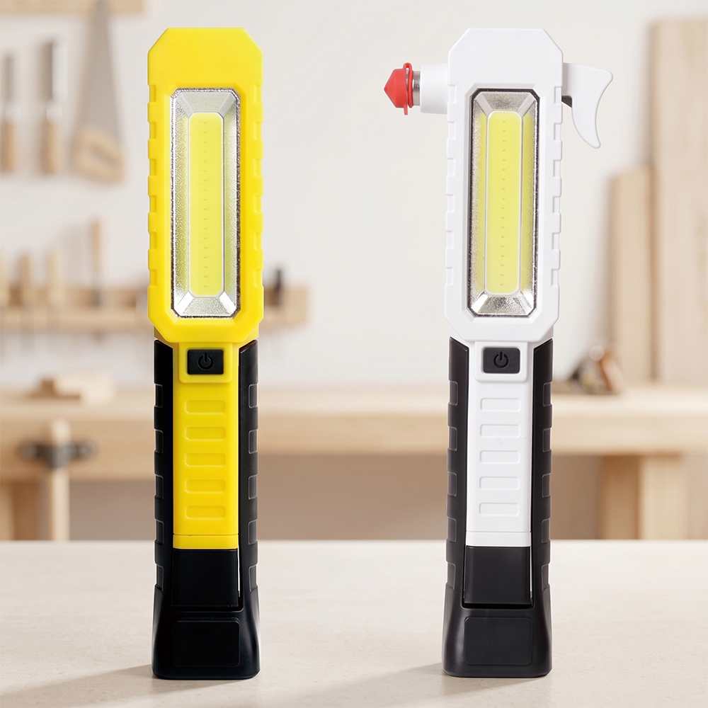 Two emergency magnetic LED work lights in yellow and white versions standing on a carpentry table.