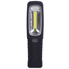 A black and red hands-free magnetic LED work light standing vertically on a rustic wooden workshop table with professional tools in the blurred background.