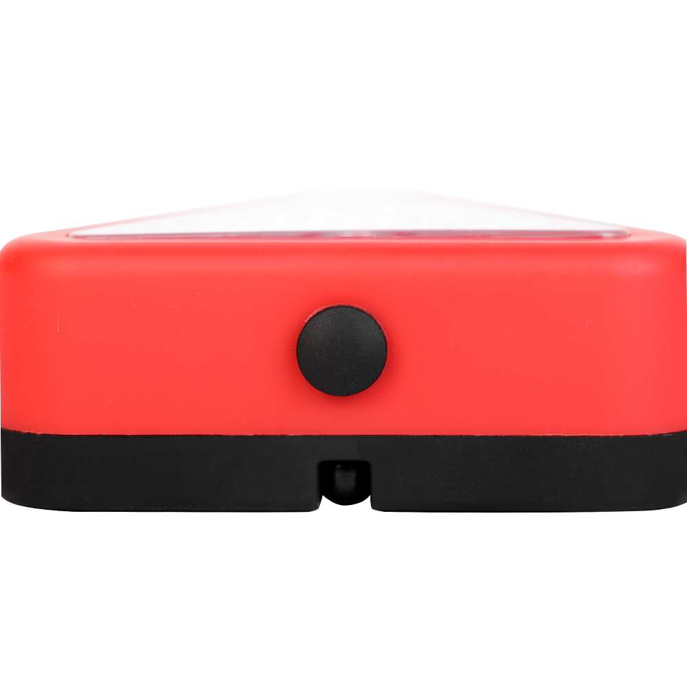 Top view of the triangle emergency LED work light focusing on the textured black silicone power switch button.