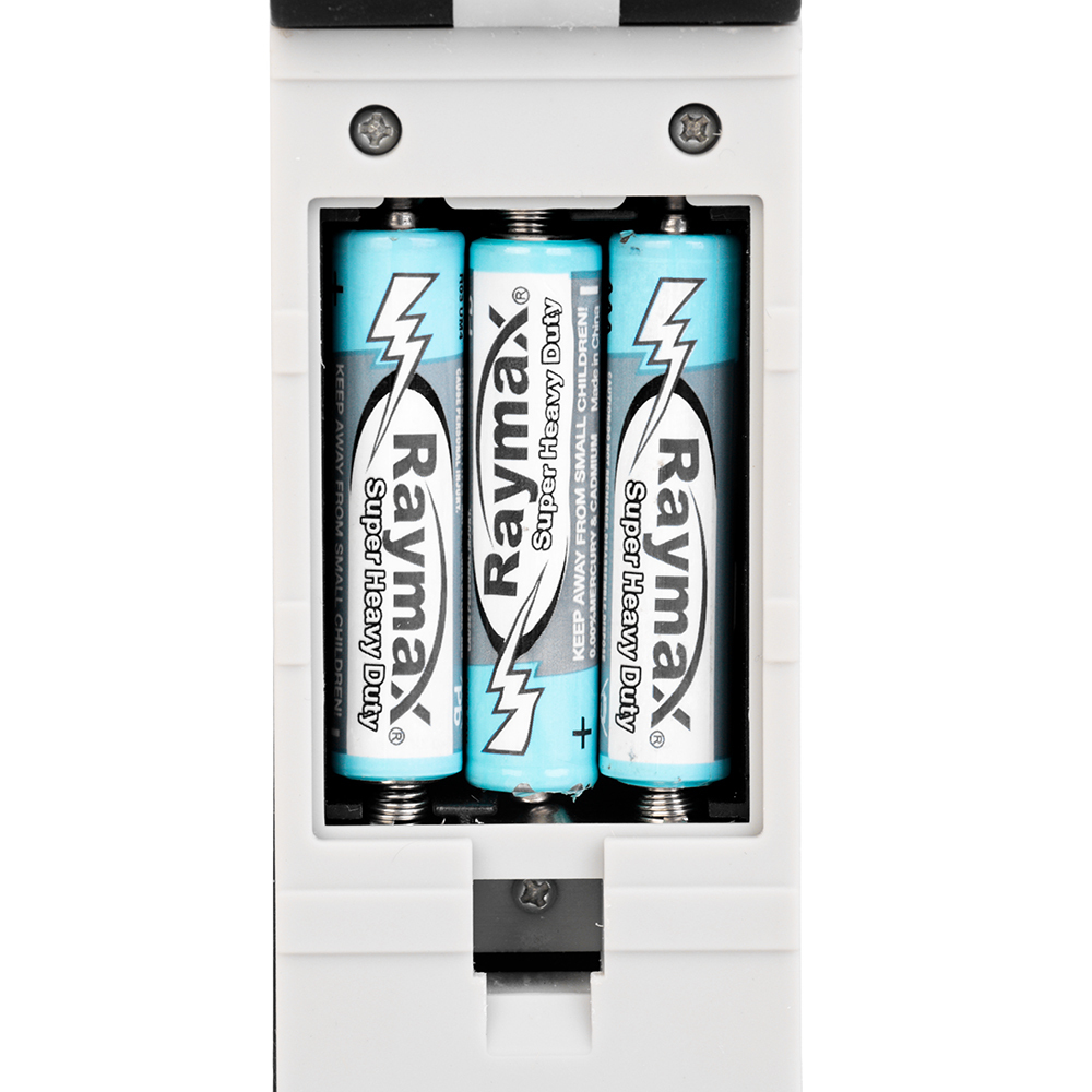 Close-up view of the battery compartment on the back of the LED work light loaded with three AAA batteries.