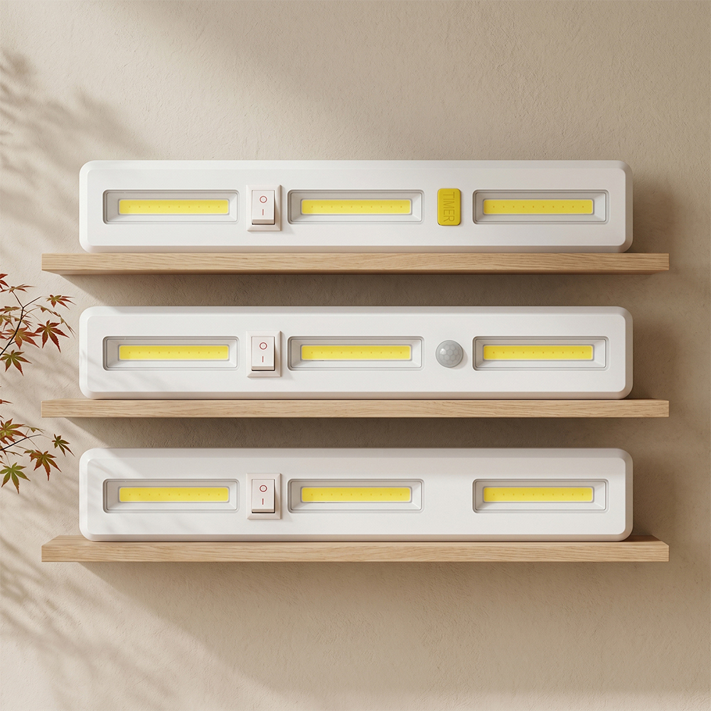 Three white rectangular COB LED light bars stacked horizontally on wooden display shelves, showing the timer, motion sensor, and standard models.