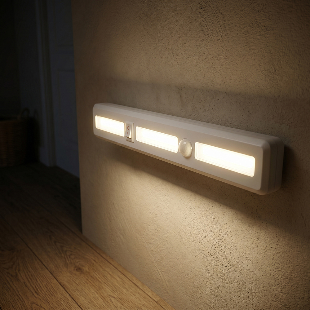 An automatic motion sensor LED light bar mounted on a hallway wall, casting a warm glow downward onto the wooden floor.