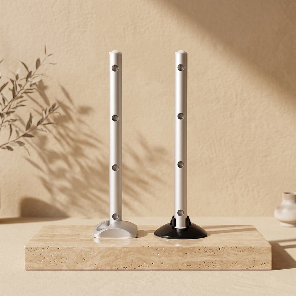 Two silver LED cabinet light bars standing vertically on a wooden block, showing the square base and circular base options.