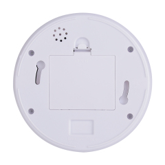 Rear view of the circular camera base plate showcasing a central square battery cover slot, two mounting keyholes, and a small perforated hole grid.