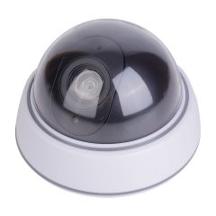 Side perspective view of the dome-shaped fake security camera showing the curved profile of the dark transparent shield and plastic casing on a white background.