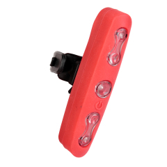 Side perspective view of the red silicone bicycle rear light with the black mounting clip locked into its back track.
