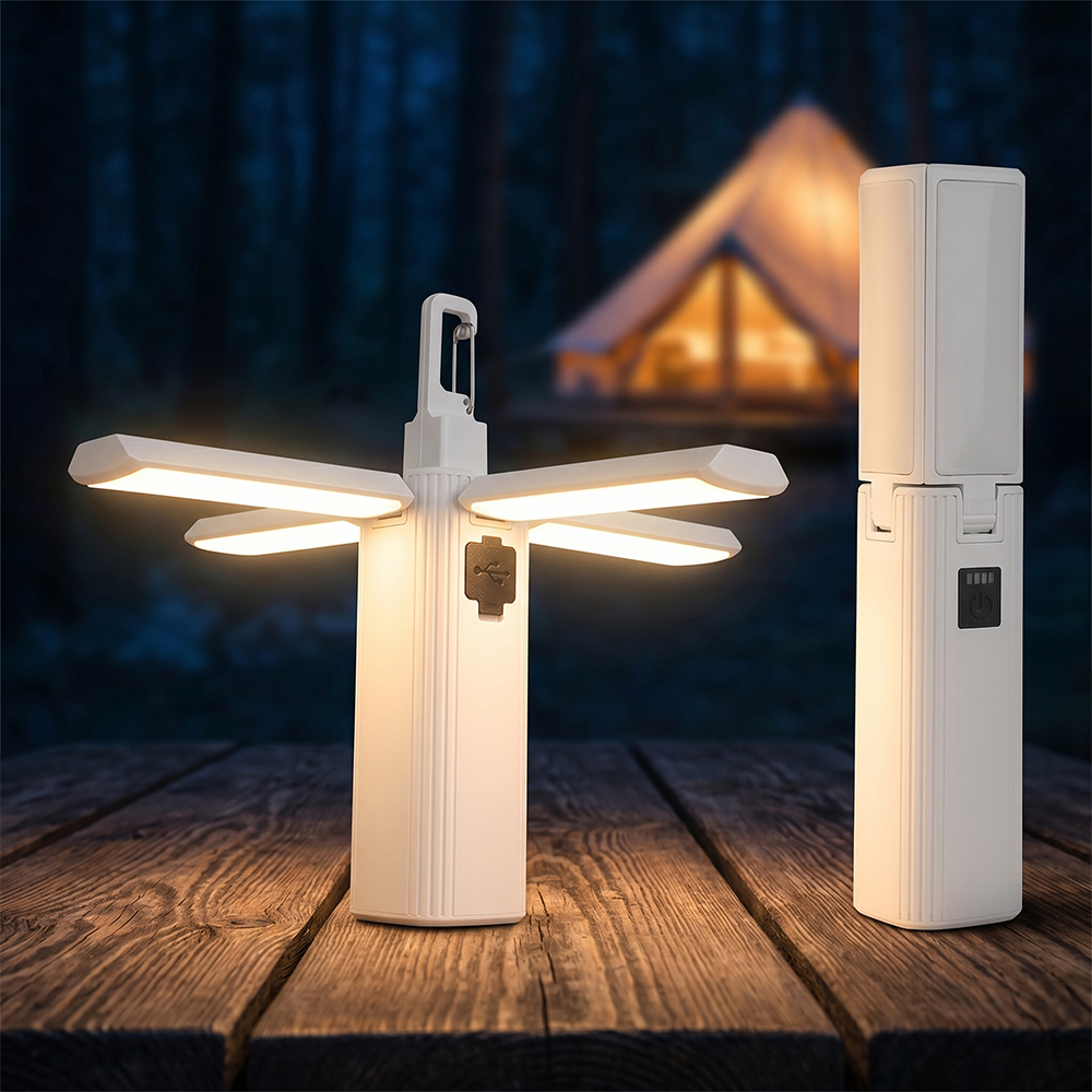 A white multi-functional LED camping light standing on a outdoor wooden table at night, with one unit expanded into a clover shape emitting light and another fully folded.
