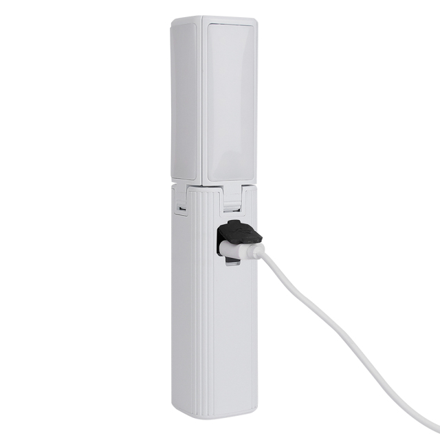 A close-up side view of the white rechargeable LED work light with its rubber port cover open and a white USB cable plugged in for charging.